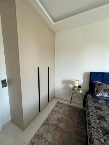 a bedroom with white cabinets and a blue bed at Best Home 38 Triumph in Alanya