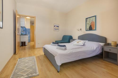 a bedroom with a bed and a blue chair at PINE&SHINE Waterfront in Podgora