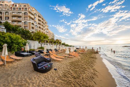 a beach with lounge chairs and umbrellas and the ocean at Luxurious and panoramic apartments at the beach in La Mer complex in Golden Sands