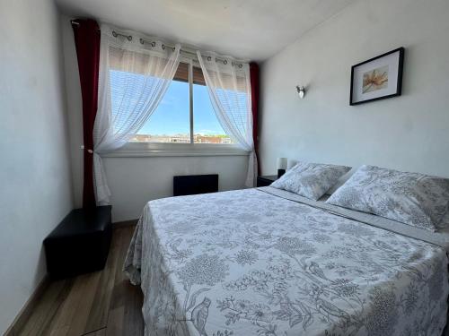 a bedroom with a bed and a large window at Appartement Port Marianne Montpellier in Montpellier