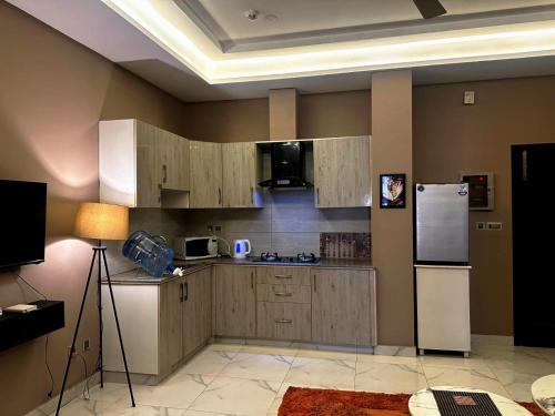 a kitchen with wooden cabinets and a white refrigerator at River Hill in Rawalpindi