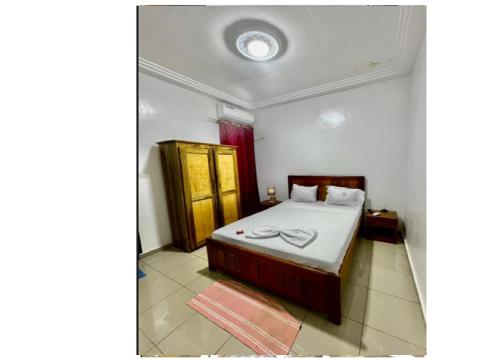 a small bedroom with a bed and a mirror at Résidence ADJOBIA - Grâce divine YAMOUSSOUKRO in Yamoussoukro
