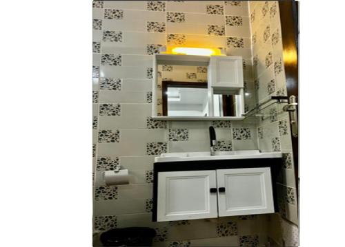 a bathroom with a white sink and a mirror at Résidence ADJOBIA - Grâce divine YAMOUSSOUKRO in Yamoussoukro