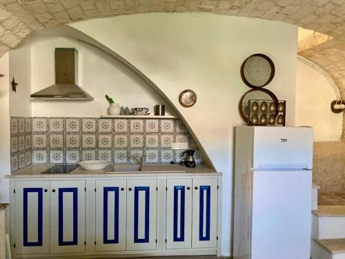 a kitchen with a white cabinet and a white refrigerator at Pedra e Lozzu in Sedini