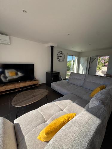 a living room with a couch and a tv at Villa Mathilde - 3 Chambres - Jacuzzi in Béziers