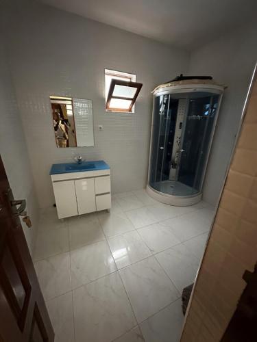 a bathroom with a shower and a sink and a mirror at Recanto da Paz in Tarrafal