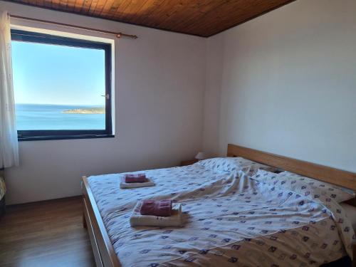 a bedroom with a bed with a large window at Sunset Zaglav Apartment in Martinšćica