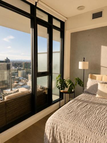 a bedroom with a bed and a large window at The Alpine City Escape in Calgary