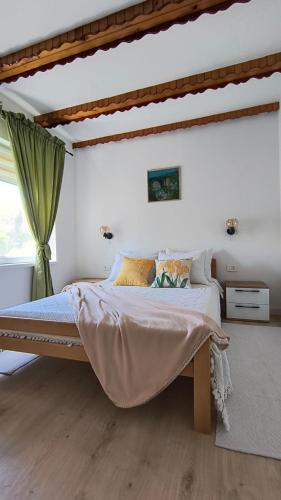 ein Schlafzimmer mit einem großen Bett und einem Fenster in der Unterkunft Apartments Celopek in Ličko Petrovo Selo
