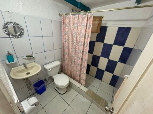 a small bathroom with a toilet and a sink at Hostal Cabañas Don Jorge in Puerto Baquerizo Moreno