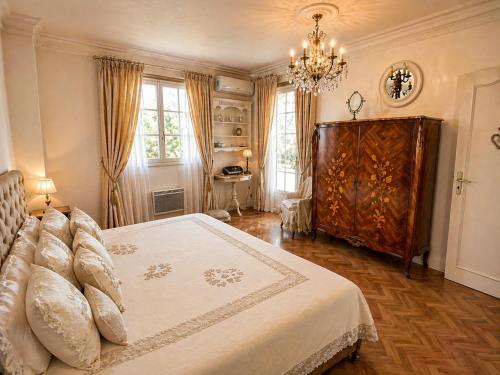 a bedroom with a large bed and a chandelier at Villa Daurus in Vallauris