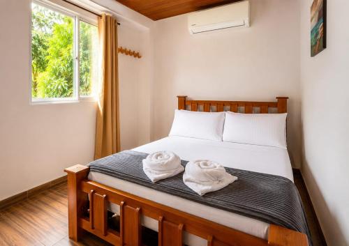 a bedroom with a bed with two towels on it at Hostal Nomadax Tayrona in El Zaino