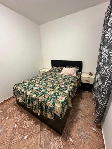 a bedroom with a bed with a green comforter at Recanto da Paz in Tarrafal