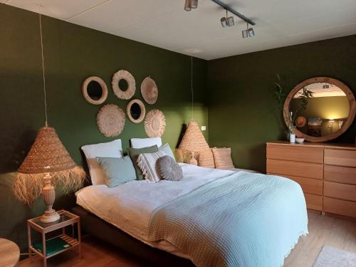 a bedroom with a large bed and a mirror at La Chamallow Cœur d'Artichaud in Dinant