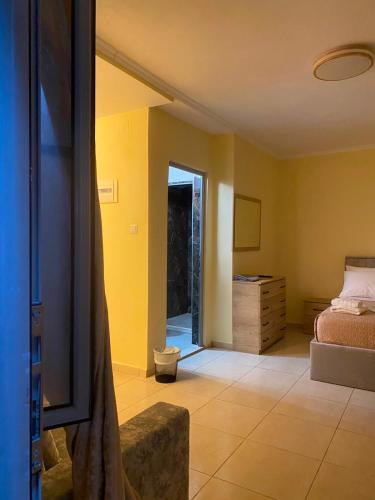 a bedroom with a bed and a dresser and a television at Dina's Rooms Himara in Himare