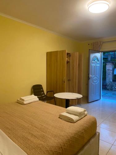 a bedroom with a bed and a table and a door at Dina's Rooms Himara in Himare