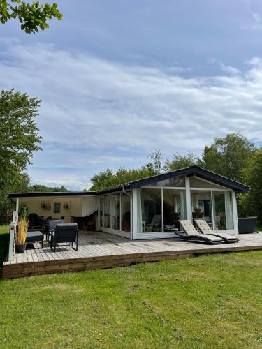 a house with a deck with chairs on it at Charming House Close To The Beach in Gedser