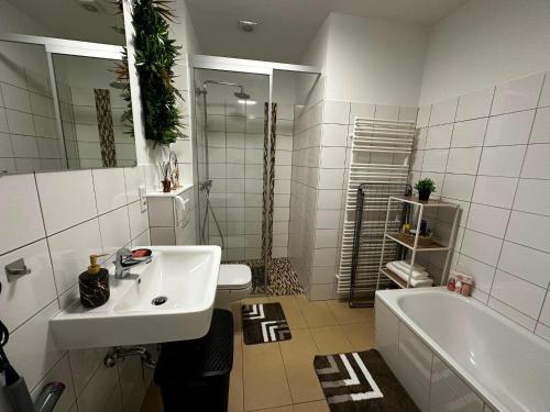 a bathroom with a sink and a tub and a toilet at Lesum View Apartment Bremen in Bremen