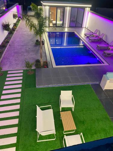 a house with a swimming pool and lawn with chairs at Aurora villa in Rrushkull