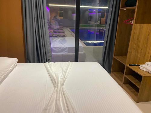 a bedroom with a white bed and a walk in closet at Aurora villa in Rrushkull
