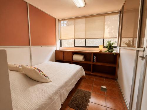 a small room with a bed and a window at Mariachi House in Mexico City