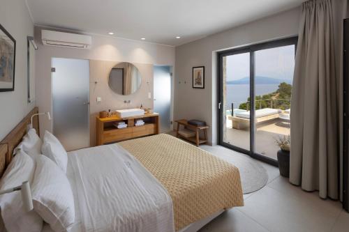 a bedroom with a bed and a bathroom with a view at Kechria Bay Villas in Skiathos