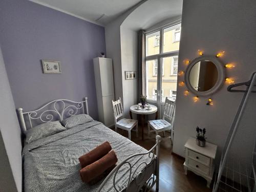 a bedroom with a bed and a mirror and a table at Prowansalski Sen - pokój z łazienką nr 3 in Poznań
