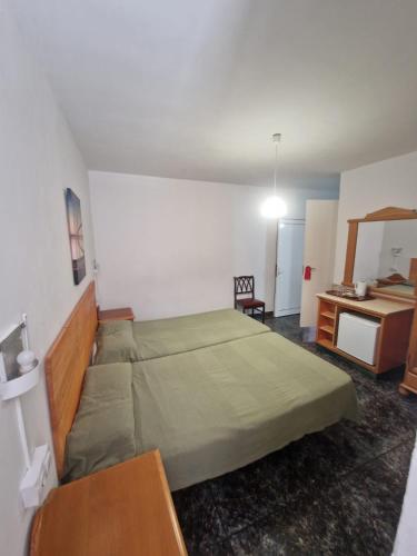 a bedroom with a large bed and a desk at Hostal Maxorata in Morro del Jable
