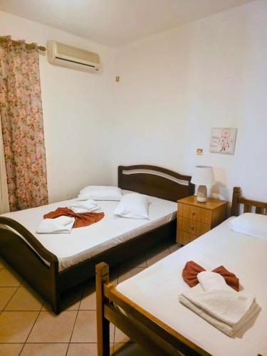 a room with two beds and a table with a lamp at Pansion Panorama in Skala Marion