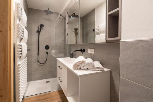 a white bathroom with a shower and a sink at Resi´s Stadthaus in Kitzbühel