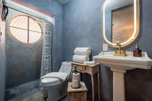 a bathroom with a sink and a toilet and a mirror at De Frente al Sol Teotihuacan in San Juan Teotihuacán