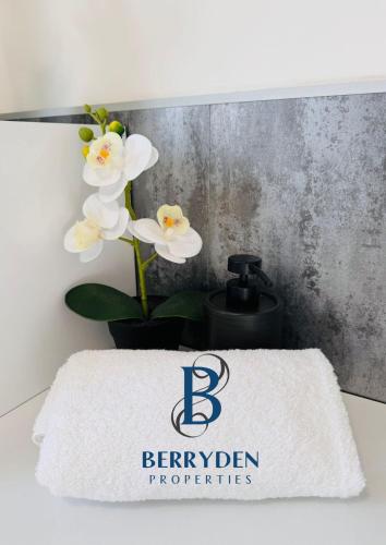 a white flower in a vase next to a towel at Aalesund stay in Peterhead