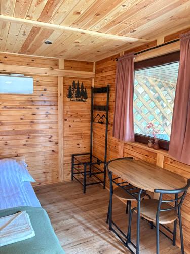a log cabin with a table and a bed at Sigła w sidłach in Aleksandrów