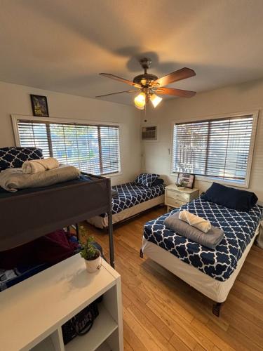 a bedroom with two beds and a ceiling fan at The Ardmore Home Share in Los Angeles