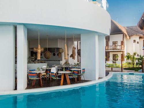 a house with a swimming pool next to a house at Villas HM Palapas del Mar in Holbox Island