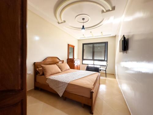 a bedroom with a bed and a window at Catrass Oualidia Apartments in Oualidia