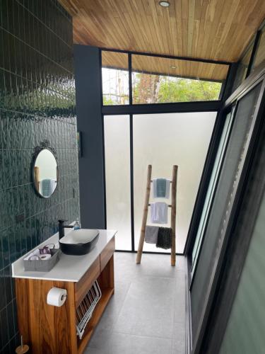 a bathroom with a sink and a large window at AsiaTica Lodge Volcano and Lake View in El Castillo de La Fortuna