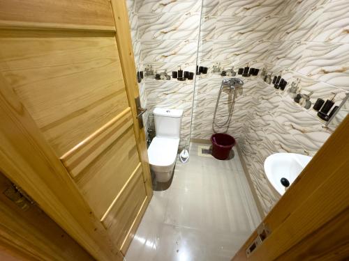 a bathroom with a toilet and a sink and a door at Catrass Oualidia Apartments in Oualidia