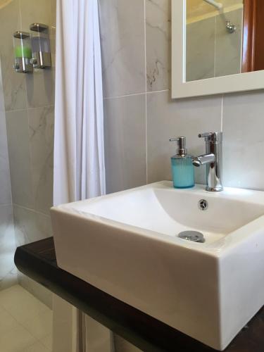 - Baño con lavabo blanco y ducha en Hotel Casa Maya Calakmul, en Chicanna