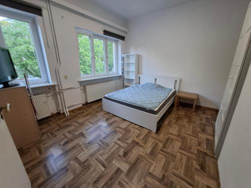 a bedroom with a bed and a wooden floor at Pokoje na lato Gdynia in Gdynia