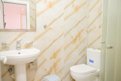 a bathroom with a sink and a toilet and a mirror at Vila Vitoria in Shëngjin