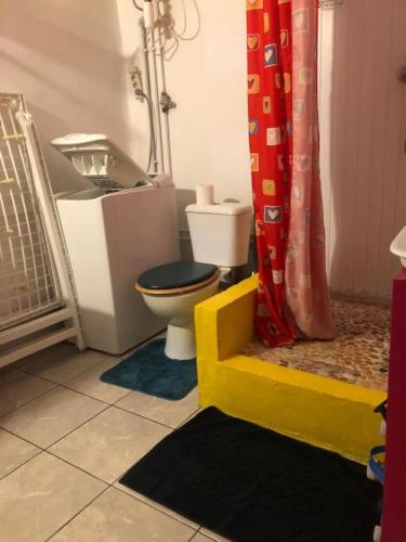 a bathroom with a toilet and a shower curtain at Nid du Lagon in Sainte-Anne