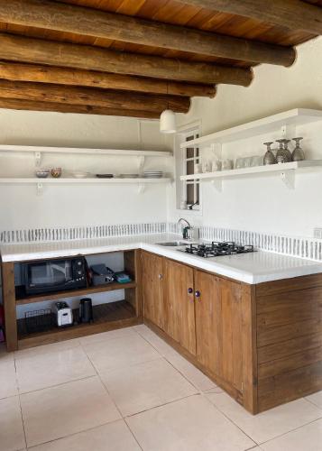 a kitchen with wooden cabinets and a white counter top at Casa Fluila in Praia do Rosa