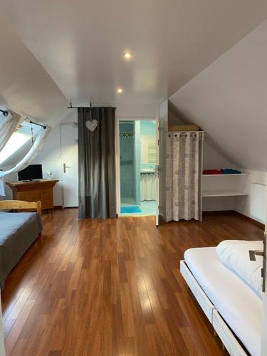 a attic bedroom with a bed and a shower at La cour des hôtes in Fenain
