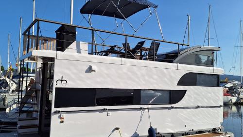 a white boat is docked in the water at Duerme en un barco in Moaña