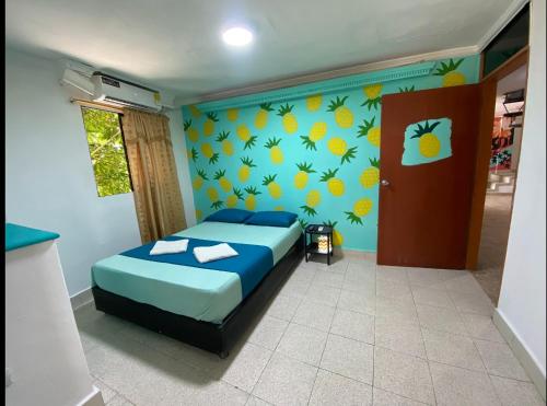 a bedroom with a bed and a wall with oranges at Tamarindo in Santa Marta