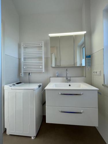 a white bathroom with a sink and a mirror at Ferienwohnung Hoherting in Prien am Chiemsee
