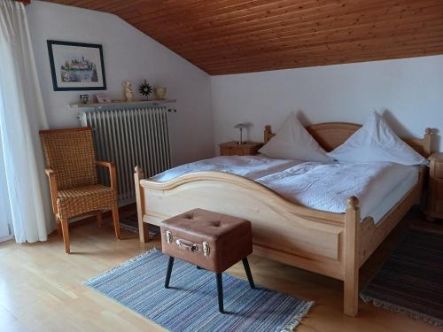 a bedroom with a large bed and a chair at Haus Huber in Übersee