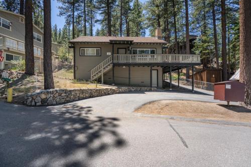 a large house with a deck and a driveway at Foothill Folly home in Zephyr Cove