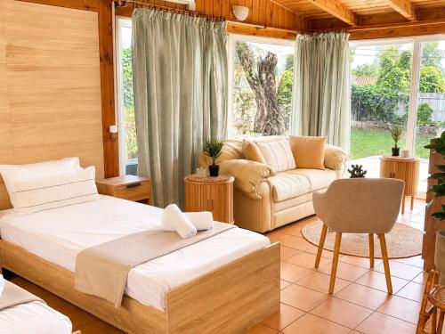 a bedroom with a bed and a couch at KATIA BEACH Holiday Cottage in Kassiopi